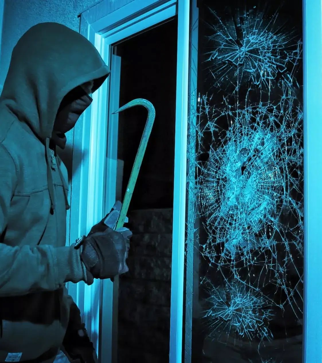 a robber breaking glass with a security film